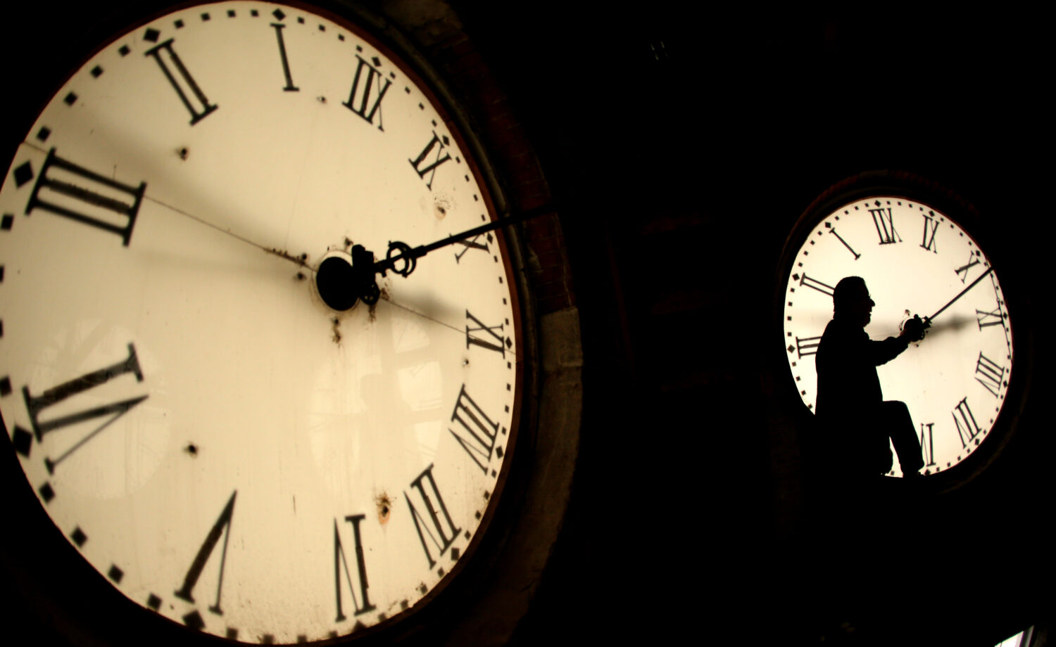 FILE - Custodian Ray Keen inspects a clock face before changing the time on the 100-year-old clock ...