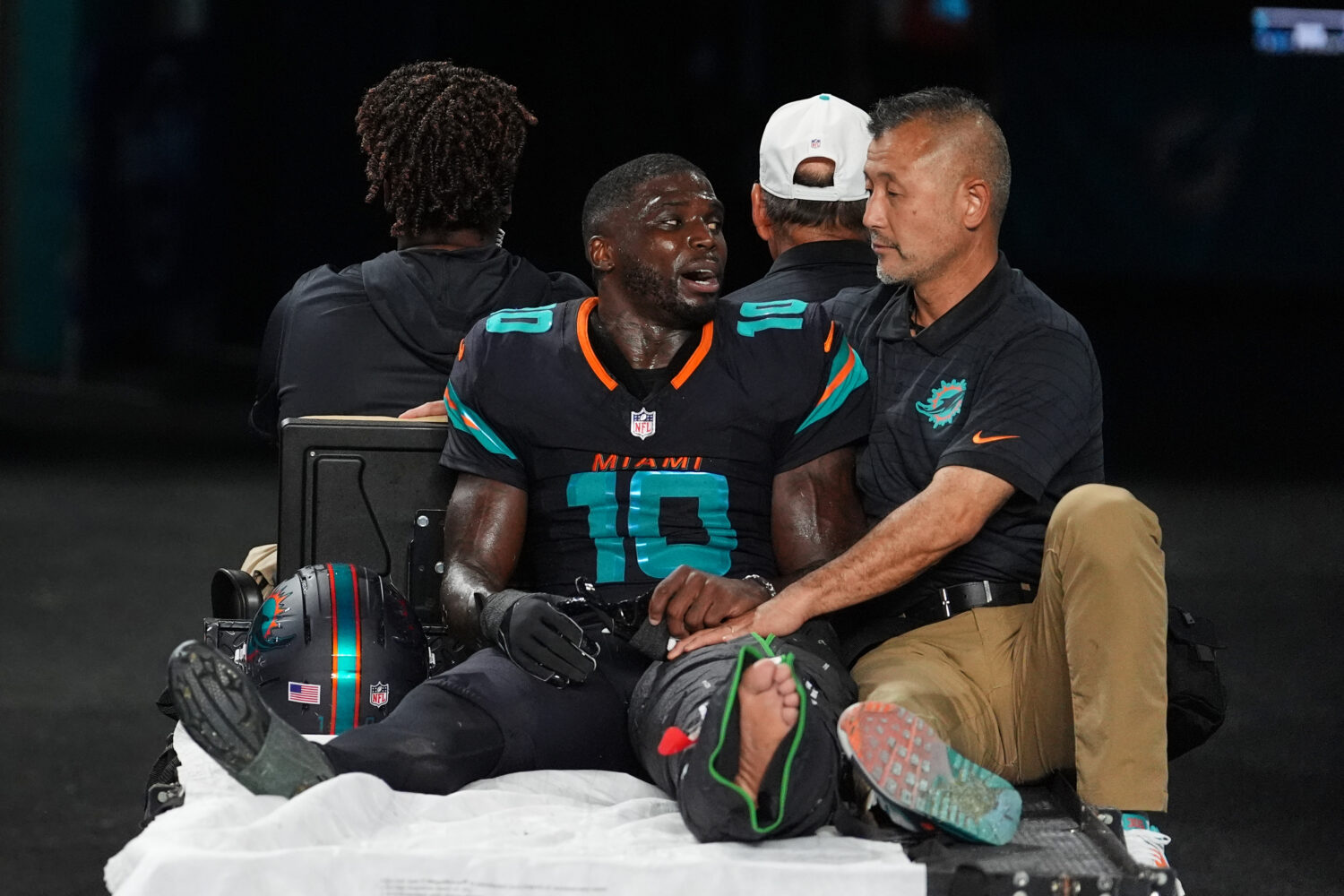 Miami Dolphins wide receiver Tyreek Hill (10) talks with a staff member as he is carted off the fie...