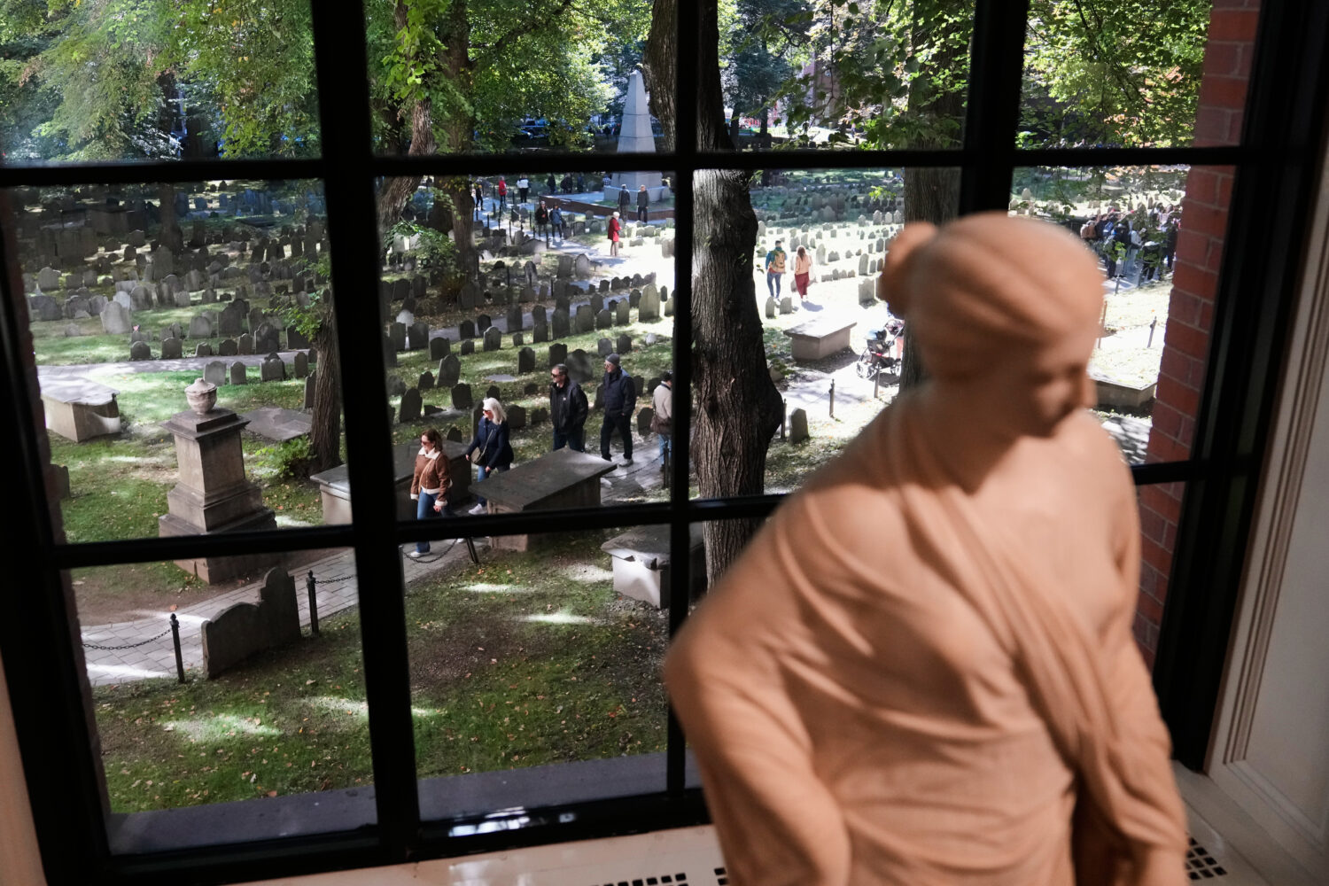 Visitors walk though the Granary Burying Ground, which includes the graves of John Hancock, Samuel ...