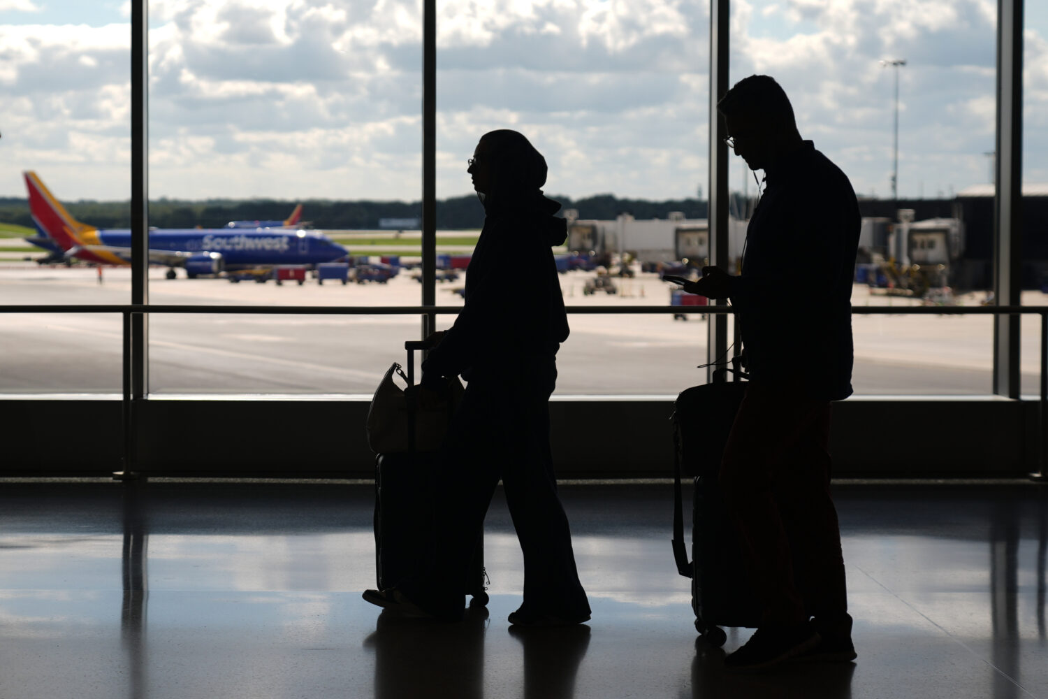 Travelers walk through the Baltimore/Washington International Thurgood Marshall Airport, Thursday, ...