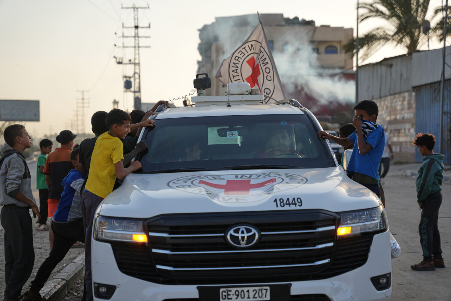 Palestinian kids look into a Red Cross vehicles carrying the bodies of two people believed to be de...