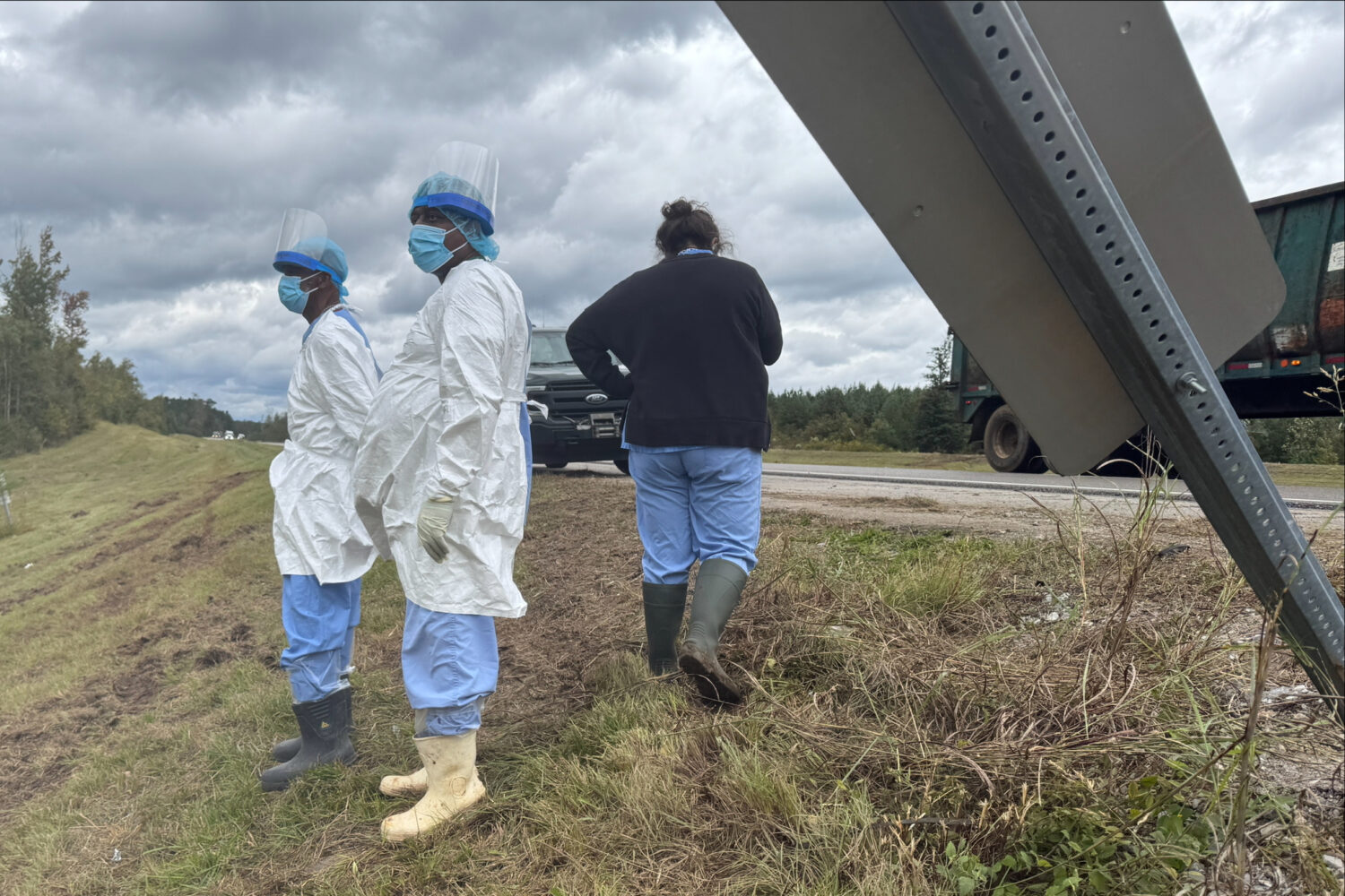 People wearing protective clothing search along a highway in Heidelberg, Miss., on Wednesday, Oct. ...