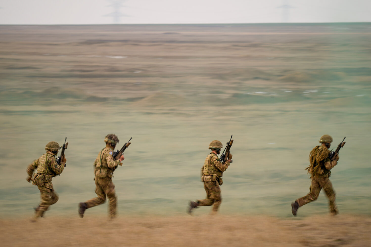 FILE- Servicemen run during the Steadfast Dart 2025 exercise, involving some 10,000 troops in three...