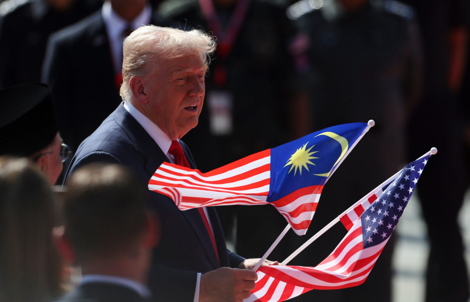 U.S. President Donald Trump holds the Malaysia and U.S. flags during a welcoming ceremony as he arr...