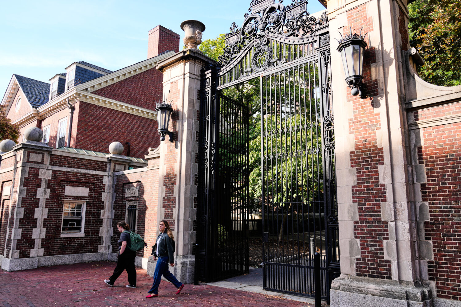 Two women walk through a gate from Harvard Yard at Harvard University, Tuesday, Sept. 30, 2025, in ...