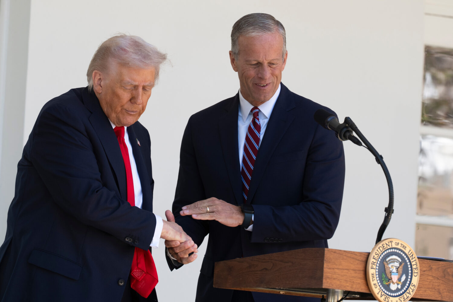 President Donald Trump shakes hands with Senate Majority Leader John Thune, R-S.D., right, during a...